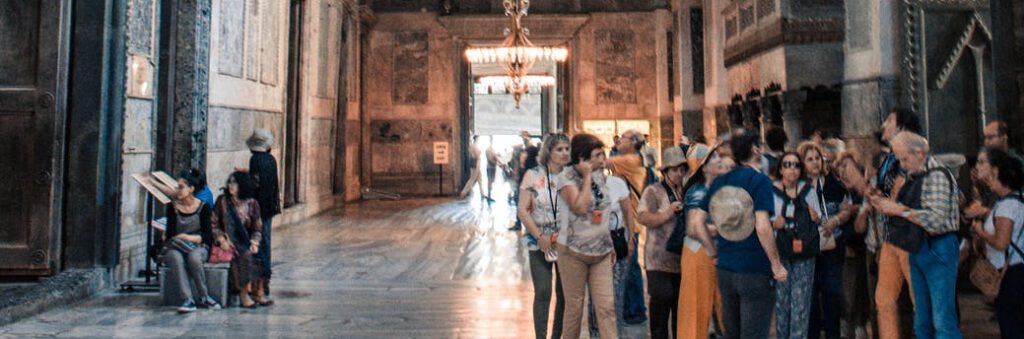 anonymous tourists admiring interior of ancient church
